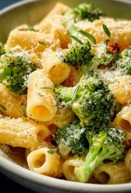 Creamy vegetarian broccoli cheddar pasta served in a bowl with fresh herbs on top.