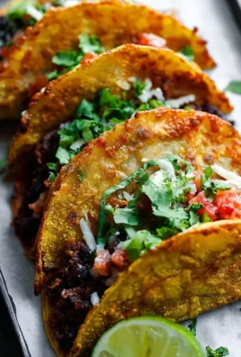 Crispy black bean tacos topped with fresh ingredients and served on a plate