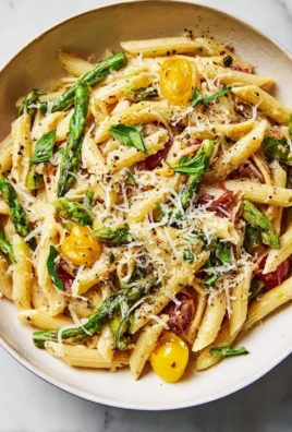 A colorful bowl of Pasta Primavera with fresh vegetables and herbs