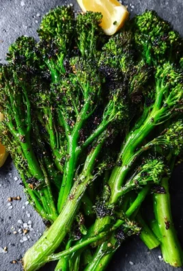 Delicious roasted broccolini garnished with seasoning on a white plate