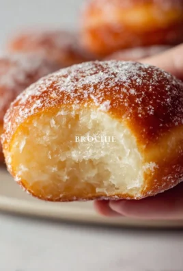 Freshly made brioche donuts topped with glaze.