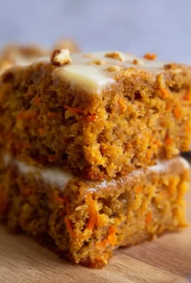 Slice of flourless oatmeal carrot cake on a plate with fresh carrots and oats.
